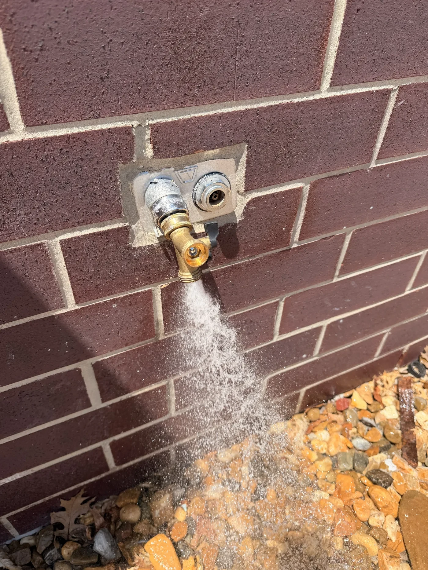Outdoor hose bib running on a brick wall on West Heritage Drive in Tyler, Texas