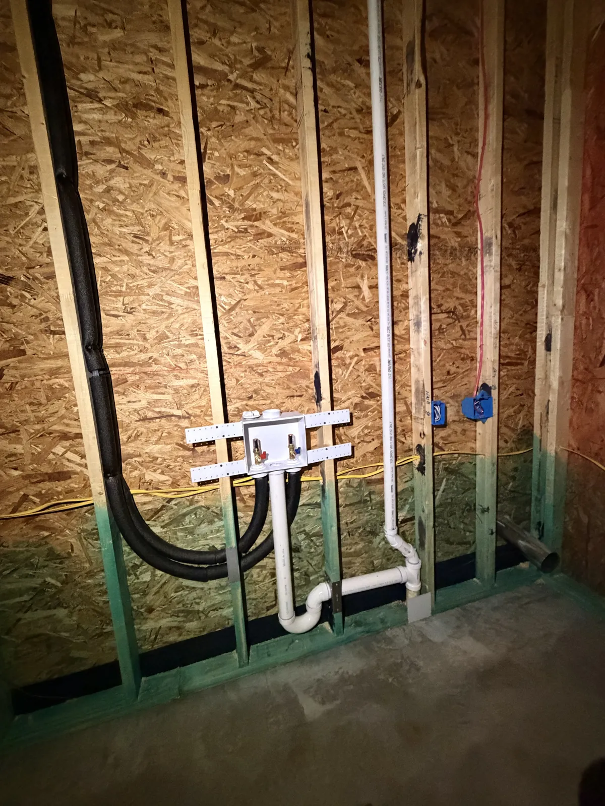 Laundry rough-in with washer box, drain trap and supply lines in the framing on Hidden Creek Trail, Legacy Bend, Tyler TX