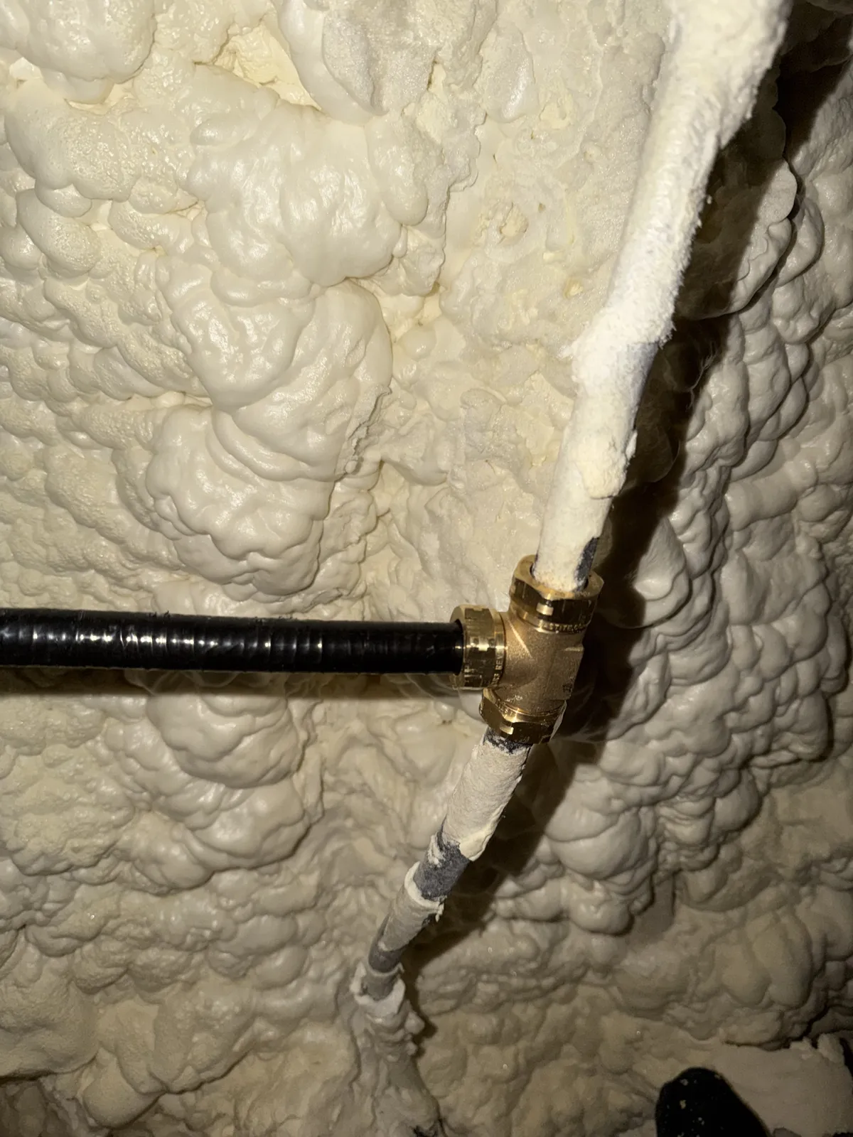 Gas line with a brass tee run through a spray-foamed attic on Hidden Creek Trail, Legacy Bend, Tyler TX