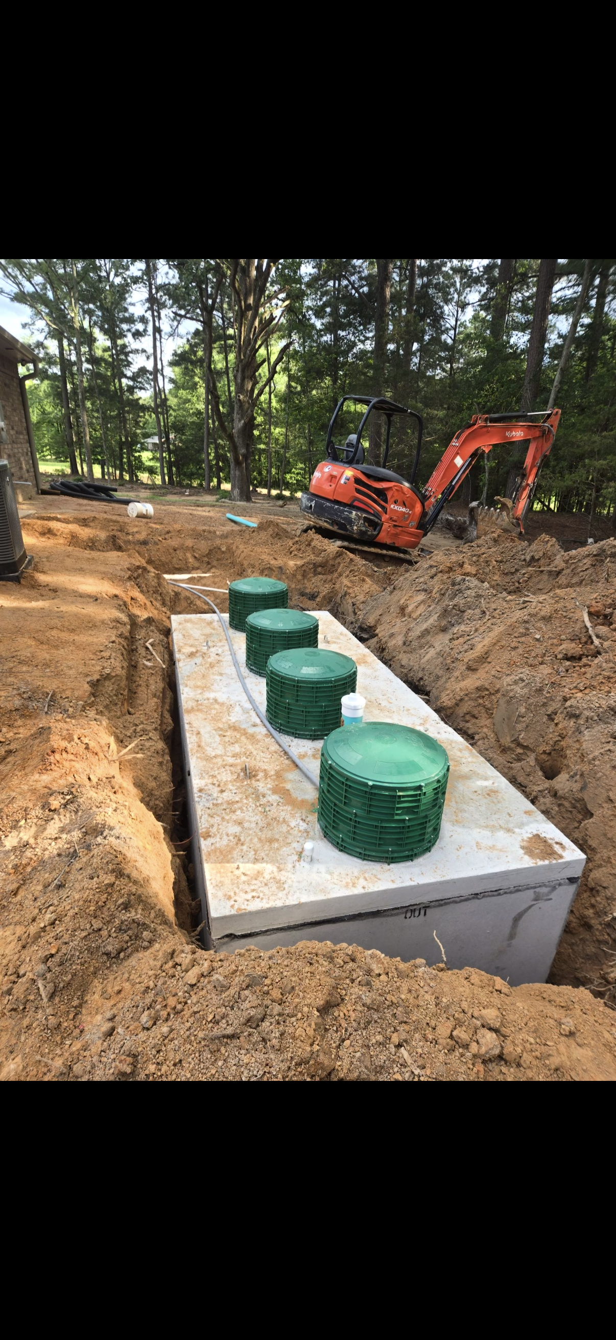 Septic tank installation with excavator in East Texas